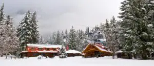 helicopter flying in front of snow covered lodge